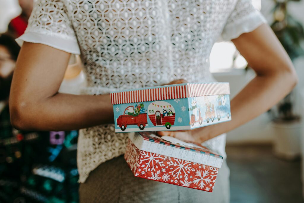 A person holding two gifts behind their back