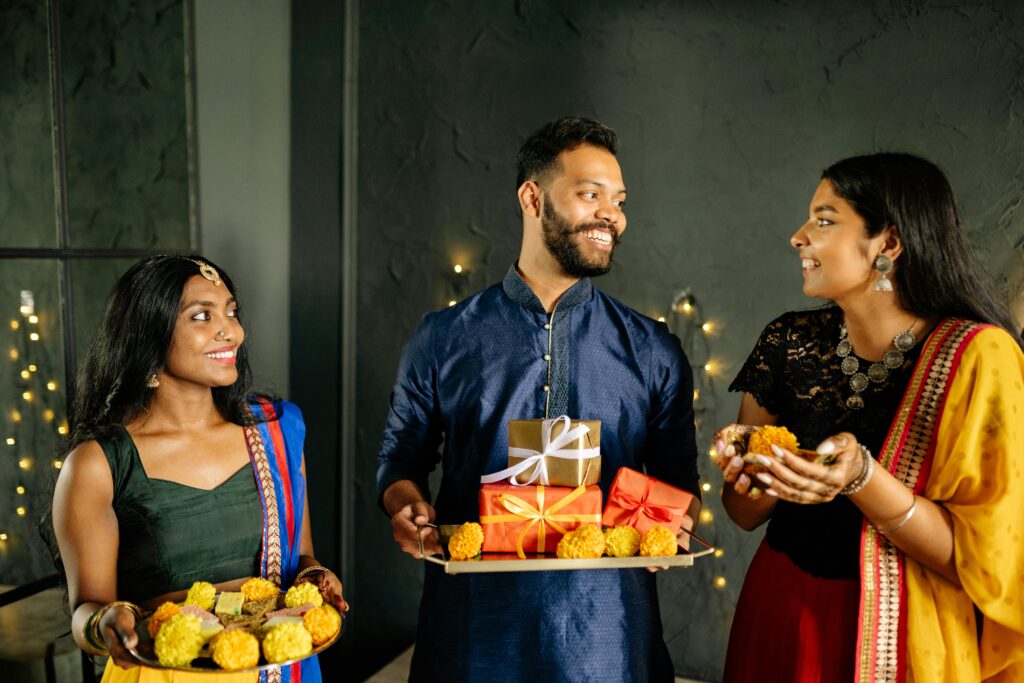 Three people dressed in gfestive Indian clothes for Diwali